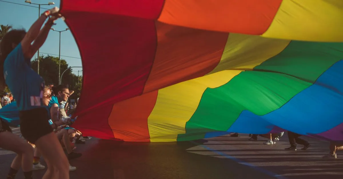 persone che sollevano bandiera arcobaleno